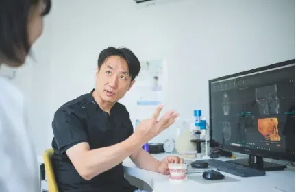 モニターを見ながら治療計画を説明する院長