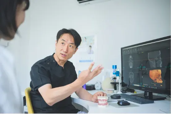 モニターを使って治療計画を説明する院長